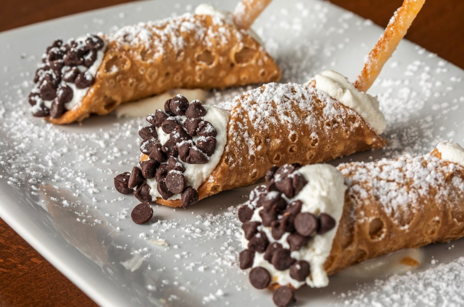 Amalfi cannoli filled with cream and chocolate chips, dusted with powdered sugar