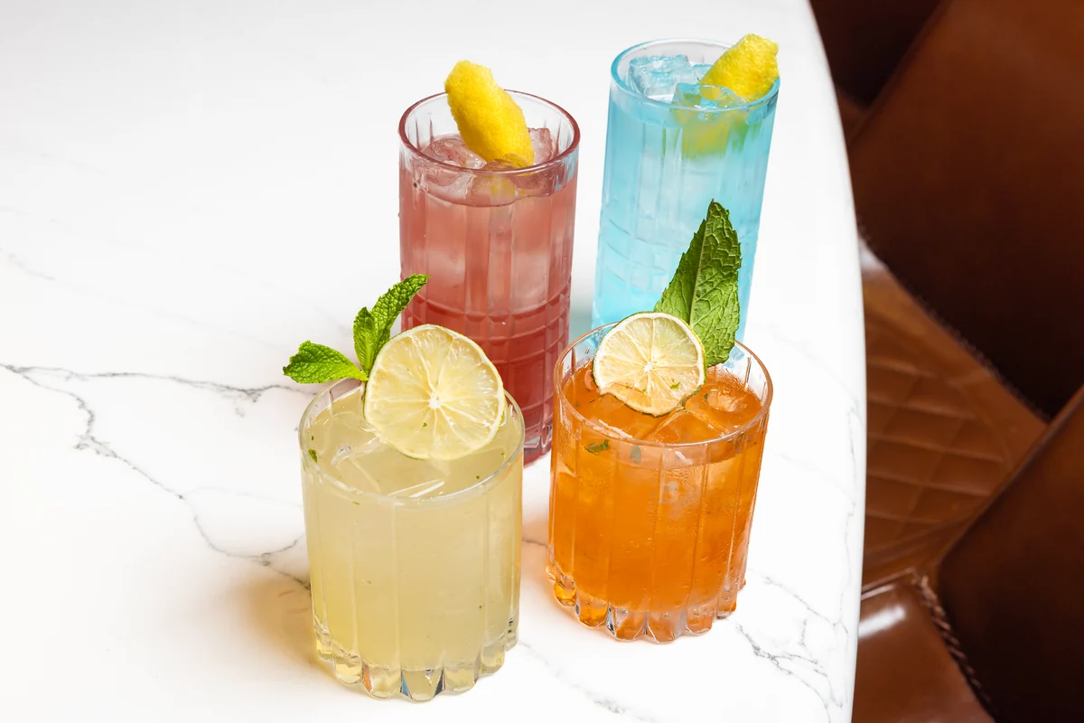 Four Peachtree Sporting Club cocktails with their garnishes