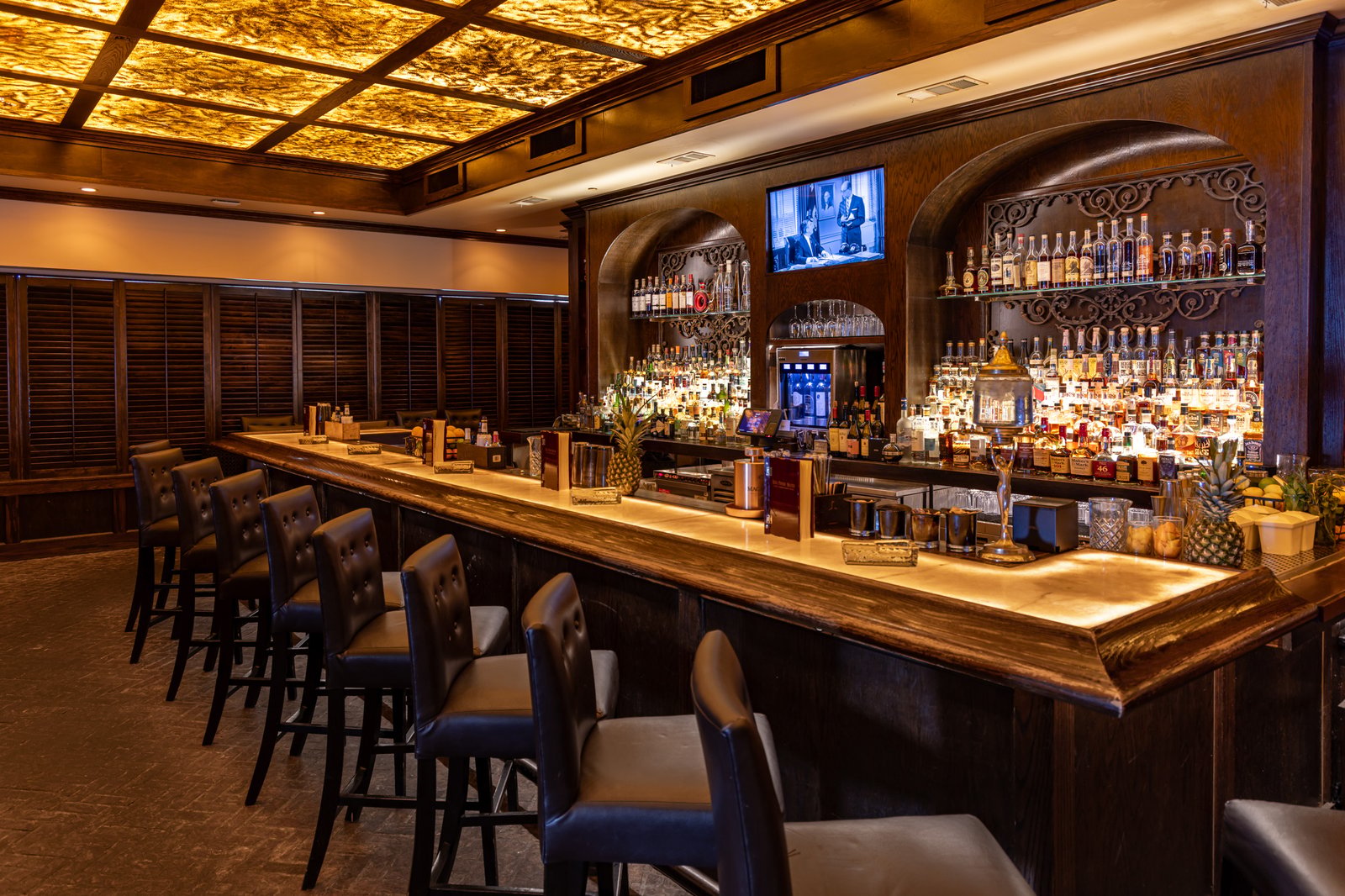The illuminated onyx bar and leather bar stools inside Red Phone Booth