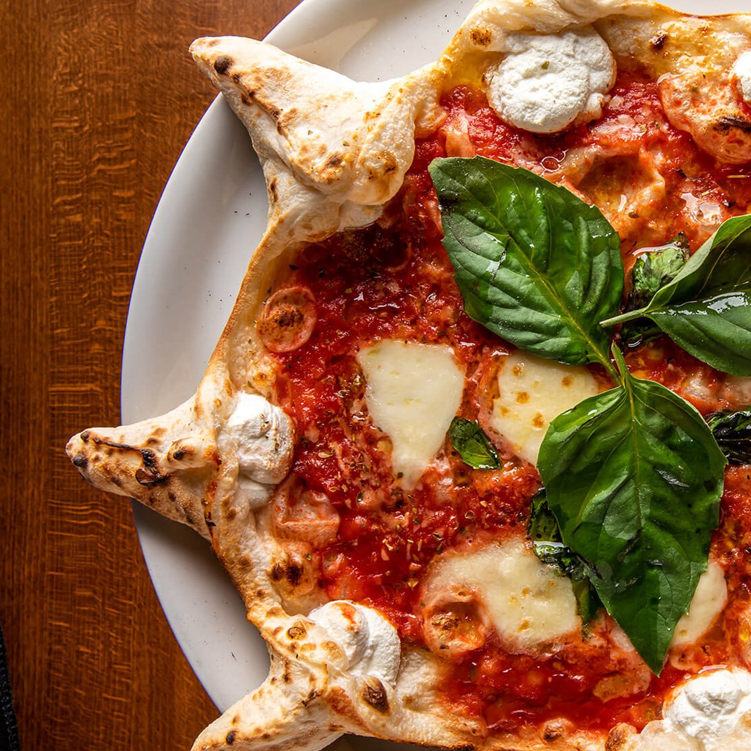 Neapolitan pizza topped with tomato, mozzarella and fresh basil from the Red Phone Booth menu