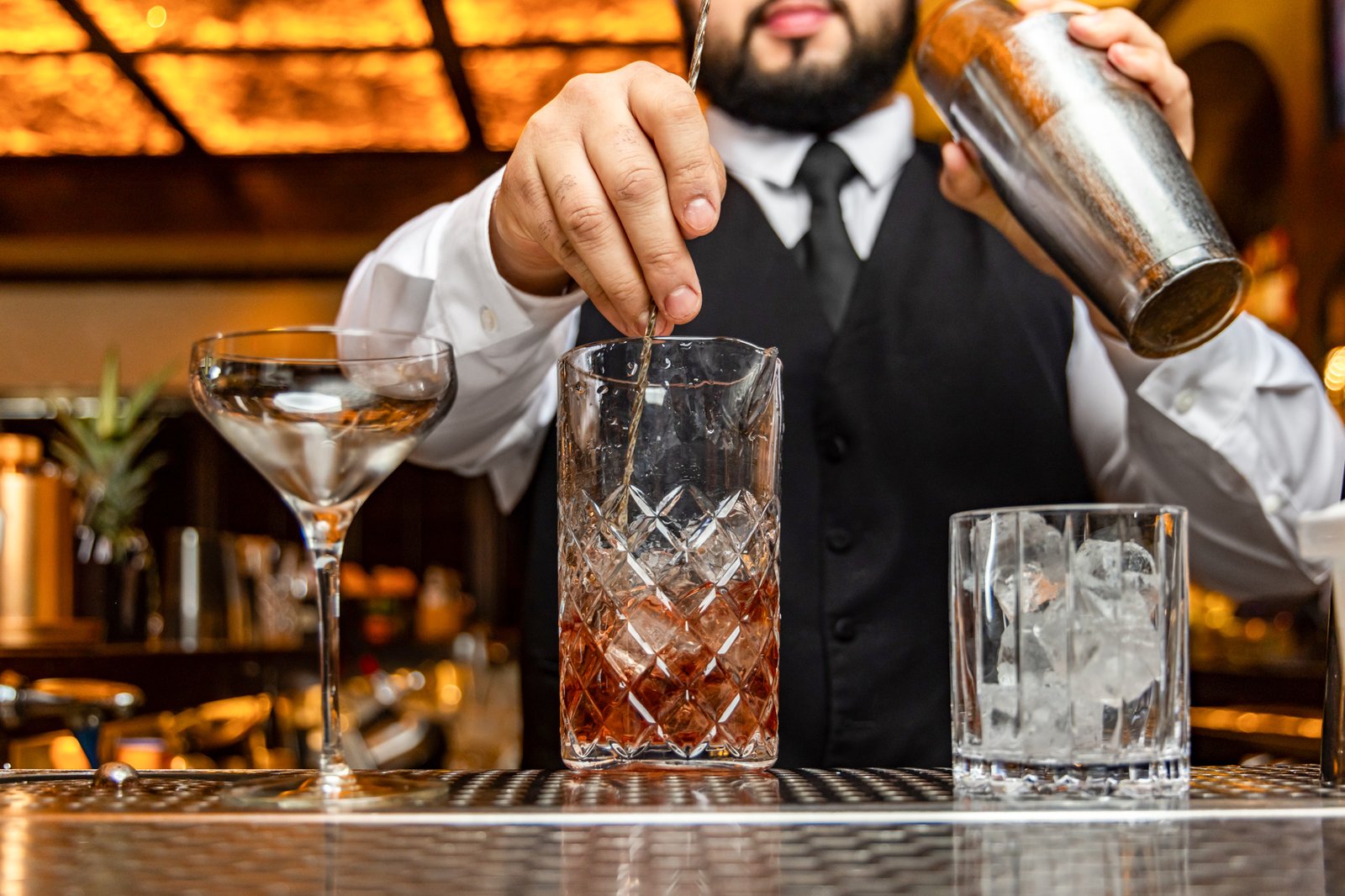 A Red Phone Booth bartender stirs a cocktail in a crystal mixing glass